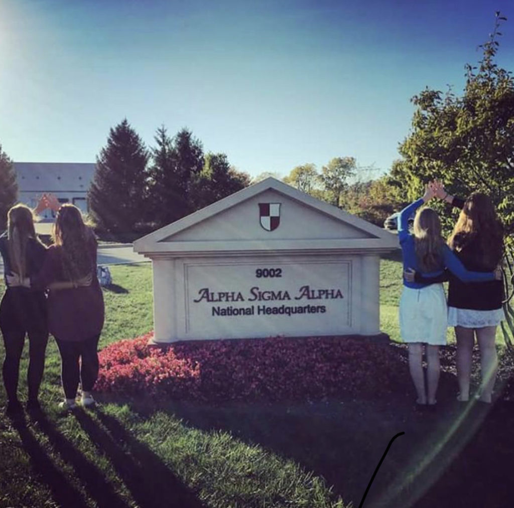 Four women standing outside of Alpha Sigma Alpha's headquarters.